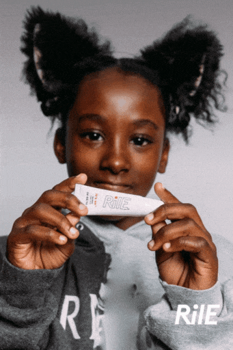 A young teen or tween girl is pushing the Rile lip balm to camera. She is smiling and the text reads it's on yes it is.